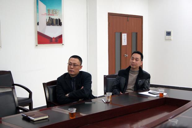 图5、宏陶抛光砖销售副总张彦（左一）、宏陶广东线销售副总庞永江（右一）认真观看参评专卖店幻灯片播放效果